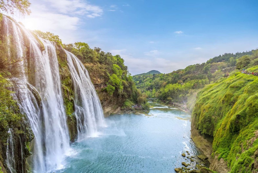 Landschap Wallgroup | Rustgevende Waterval Naar Een Rivier Fotobehang