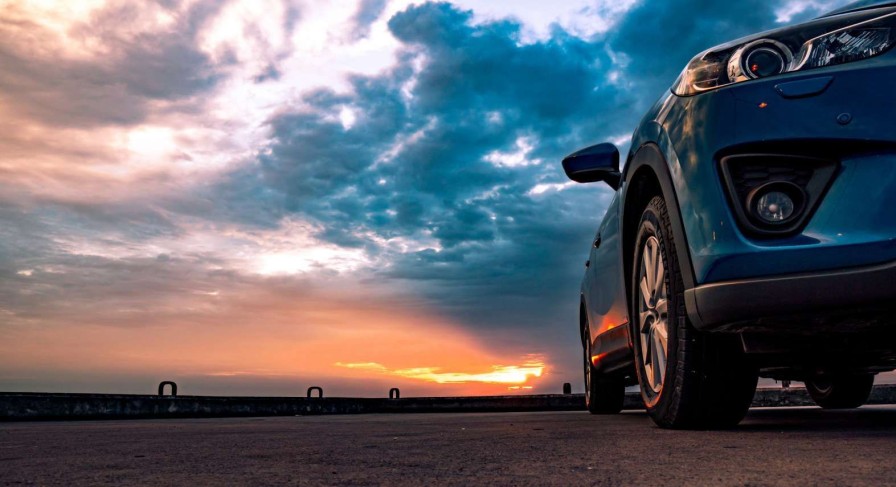 Transport Wallgroup | Een Blauwe Suv Met Een Unieke Lucht Op De Achtergrond Fotobehang