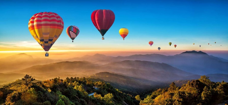 Landschap Wallgroup | Grote Groep Luchtballonnen Boven Een Mistig Berglandschap Fotobehang