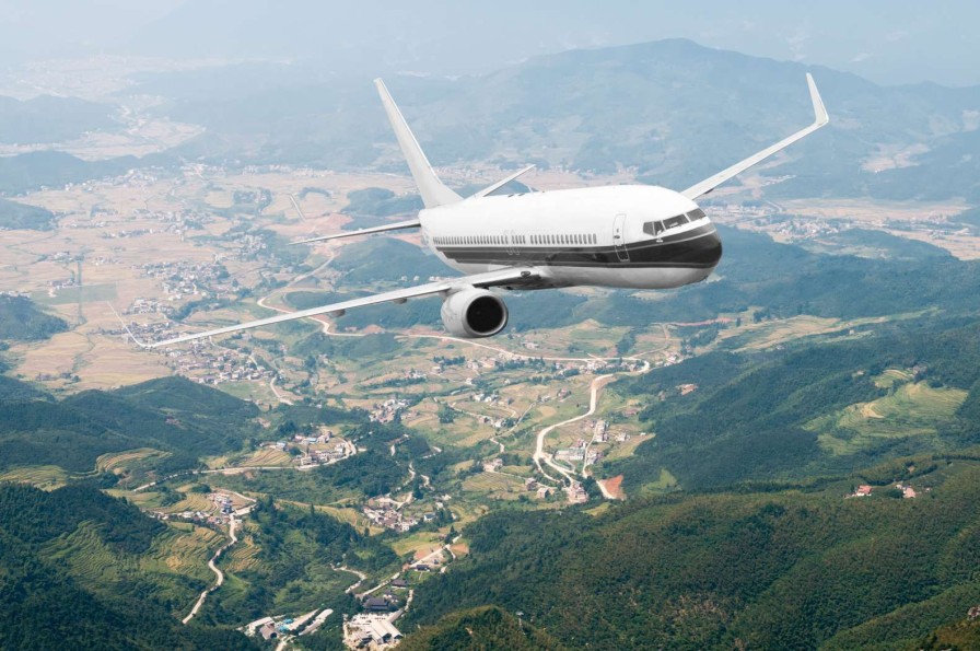 Transport Wallgroup | Passagiersvliegtuig Boven Een Berglandschap Fotobehang